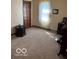 Cozy bedroom with neutral carpet, light walls, and bright light from the large window at 7334 Fairwood Cir, Indianapolis, IN 46256