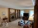 Open living room featuring a brick fireplace, built in shelves, and large TV at 7334 Fairwood Cir, Indianapolis, IN 46256