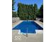 Backyard features a private in-ground pool with concrete surround and manicured landscaping at 7334 Fairwood Cir, Indianapolis, IN 46256