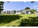 Wide backyard featuring the home with a sunroom and lush grass, surrounded by neighboring homes at 7567 Muirfield Pl, Indianapolis, IN 46237
