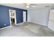 Spacious bedroom with attached bathroom, ceiling fan, and fresh carpeting at 7567 Muirfield Pl, Indianapolis, IN 46237