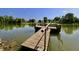 Wooden dock on a calm lake, perfect for relaxation and enjoying the scenic surroundings under a clear sky at 7567 Muirfield Pl, Indianapolis, IN 46237