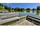 Scenic view from a dock's weathered bench, overlooking the calm lake and lush community landscape at 7567 Muirfield Pl, Indianapolis, IN 46237