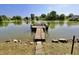 Community dock with a tranquil lake view surrounded by lush greenery and houses, offering a serene escape at 7567 Muirfield Pl, Indianapolis, IN 46237