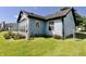 Side exterior showcasing a sunroom and well-manicured backyard with a gate at 7567 Muirfield Pl, Indianapolis, IN 46237