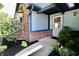 Welcoming front porch with brick accents, blue siding, a tidy landscaped garden, and a classic white front door at 7567 Muirfield Pl, Indianapolis, IN 46237