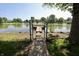 Gated access leads to a tranquil lake with a charming wooden dock at 7567 Muirfield Pl, Indianapolis, IN 46237