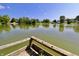 Scenic lake view with lush green trees and charming community homes under a clear blue sky at 7567 Muirfield Pl, Indianapolis, IN 46237