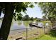 Picturesque lake view framed by lush greenery and a secure fence at 7567 Muirfield Pl, Indianapolis, IN 46237