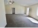 A bright, expansive living room with high ceilings and neutral carpet provides ample space for relaxation and entertainment at 7567 Muirfield Pl, Indianapolis, IN 46237