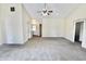 Large living room with neutral carpet, ceiling fan, and doorways trimmed with floral decor at 7567 Muirfield Pl, Indianapolis, IN 46237