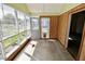 Enclosed sun room with wood paneled walls, and multiple windows overlooking the garden at 7567 Muirfield Pl, Indianapolis, IN 46237