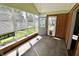 Bright sun room with wood paneling, multiple windows offering garden and neighborhood views at 7567 Muirfield Pl, Indianapolis, IN 46237