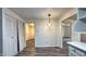 Cozy dining area with a modern light fixture, pantry closet, wood-look flooring, and bright, neutral walls at 7719 Grandview Dr, Indianapolis, IN 46260