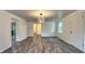 Well-lit dining room featuring wood-look floors, ample natural light, and an elegant chandelier at 7719 Grandview Dr, Indianapolis, IN 46260