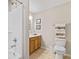 Bright bathroom with a shower-tub combo, wooden vanity, and neutral tile flooring for a clean, functional design at 7850 King Post Dr, Indianapolis, IN 46237