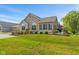 Exterior of home with stone accents, lush lawn, and a charming patio area at 7850 King Post Dr, Indianapolis, IN 46237
