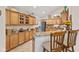 Well-lit kitchen featuring wood cabinets, granite countertops, stainless steel appliances, and breakfast bar with seating at 7850 King Post Dr, Indianapolis, IN 46237