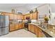 Functional kitchen with stainless steel appliances, granite counters, wood cabinets, and backsplash at 7850 King Post Dr, Indianapolis, IN 46237