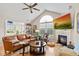 Open-concept living room with a fireplace, large windows, hardwood floors, and a comfortable leather sofa at 7850 King Post Dr, Indianapolis, IN 46237