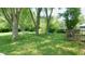 Backyard featuring a green lawn, wooden deck, fence and tall trees at 7966 Chiltern Dr, Indianapolis, IN 46268