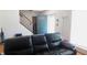 Cozy living room showcasing a comfortable black leather sofa and staircase, creating a relaxing atmosphere at 7966 Chiltern Dr, Indianapolis, IN 46268