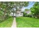 Cozy home boasts a spacious backyard with a long concrete walkway and lush greenery at 806 N Gray St, Indianapolis, IN 46201