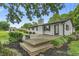 Backyard featuring a wooden deck, landscaped garden beds, and a white brick exterior at 8105 Allisonville Rd, Indianapolis, IN 46250