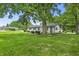 Backyard view of white brick home with mature trees and a green lawn at 8105 Allisonville Rd, Indianapolis, IN 46250