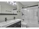 Updated bathroom features a modern vanity, sleek fixtures, and a glass-enclosed shower over tub at 8105 Allisonville Rd, Indianapolis, IN 46250