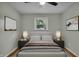 This staged bedroom features a cozy bed, side tables with lamps, and artwork over the bed at 8105 Allisonville Rd, Indianapolis, IN 46250