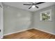 Cozy bedroom featuring hardwood floors, a ceiling fan, and natural light from a window at 8105 Allisonville Rd, Indianapolis, IN 46250