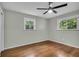 Well-lit bedroom with hardwood floors, two windows, and neutral walls at 8105 Allisonville Rd, Indianapolis, IN 46250