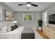 Bright bedroom featuring a ceiling fan, window overlooking foliage, neutral decor and beautiful wood floors at 8105 Allisonville Rd, Indianapolis, IN 46250