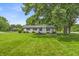 Charming home with a well-manicured lawn, beautiful trees, and a classic white brick exterior at 8105 Allisonville Rd, Indianapolis, IN 46250