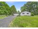Well-maintained white brick ranch-style home with attached garage, long black driveway, and landscaped front yard at 8105 Allisonville Rd, Indianapolis, IN 46250