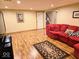 Finished basement with a red sectional couch, rug, and laminate floors at 8394 Glen Highlands Dr, Indianapolis, IN 46236