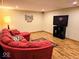 Finished basement with a red sectional couch and entertainment center offers additional living space at 8394 Glen Highlands Dr, Indianapolis, IN 46236