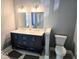 Modern bathroom features a double vanity with white countertop and contemporary lighting fixtures at 8394 Glen Highlands Dr, Indianapolis, IN 46236
