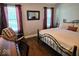 Comfortable bedroom with wood floors, an area rug, rocking chair, and natural light from windows at 8394 Glen Highlands Dr, Indianapolis, IN 46236