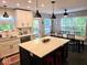 Contemporary kitchen open to the dining area featuring an island, white cabinets, and modern pendant lighting at 8394 Glen Highlands Dr, Indianapolis, IN 46236