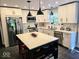 Modern kitchen with white cabinetry, stainless steel appliances, and a center island with seating and a quartz countertop at 8394 Glen Highlands Dr, Indianapolis, IN 46236