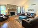 Spacious living room featuring a brick fireplace, hardwood floors, and ample natural light from large windows at 8394 Glen Highlands Dr, Indianapolis, IN 46236