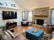Cozy living room with brick fireplace, hardwood floors, and a large television for entertainment at 8394 Glen Highlands Dr, Indianapolis, IN 46236