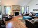 Spacious living room featuring a brick fireplace, hardwood floors, and ample natural light from large windows at 8394 Glen Highlands Dr, Indianapolis, IN 46236