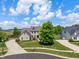 Aerial view of a brick home with manicured landscaping, circular driveway and a backyard at 8754 Lily Ct, Zionsville, IN 46077