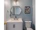 Updated powder room features a hexagon mirror, black faucet, and butterfly print at 8754 Lily Ct, Zionsville, IN 46077