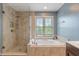 This bathroom includes a glass enclosed shower and a luxurious soaking tub under a bright window at 8754 Lily Ct, Zionsville, IN 46077