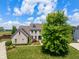 Aerial view of a well-maintained two-story brick home with a manicured lawn and mature trees at 8754 Lily Ct, Zionsville, IN 46077