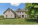 Charming two-story brick home with a manicured front lawn and a welcoming blue front door at 8754 Lily Ct, Zionsville, IN 46077
